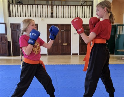 Two young Tiger Strike students practising with boxing gloves